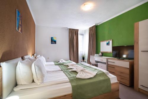a hotel room with a bed with a green wall at Grami Hotel in Bansko