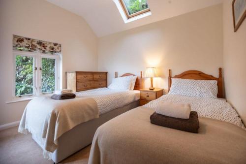 a bedroom with two beds and a window at A 3 bed cottage in Exmoor with fantastic sea views in Lynmouth