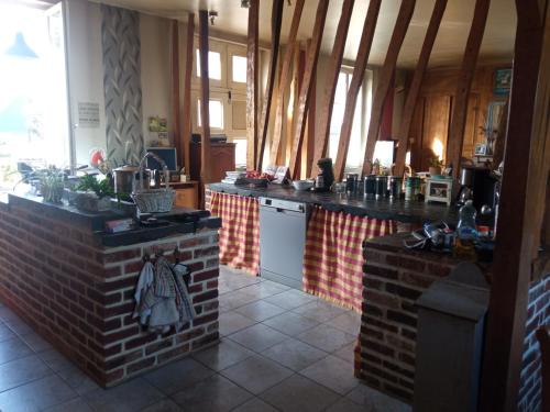 - une cuisine avec un comptoir en briques et une cuisinière dans l'établissement Chambre spacieuse et zen, à Lafresnoye