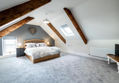 a bedroom with white walls and wooden beams at Rhos y Gadair - an incredible farmhouse by the sea in Aberporth