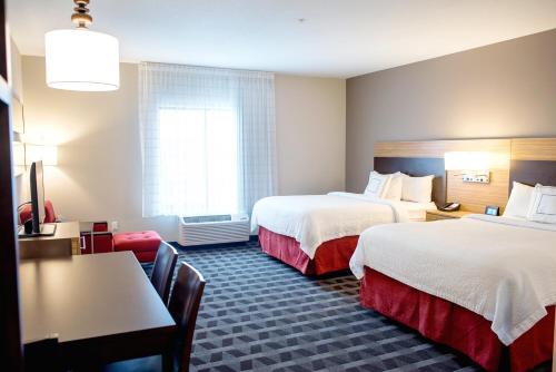 a hotel room with two beds and a table at TownePlace Suites by Marriott Ames in Ames