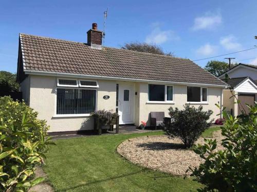 a white house with a grass yard in front of it at Crud Yr Awel, Dinas, Pembrokeshire in Dinas
