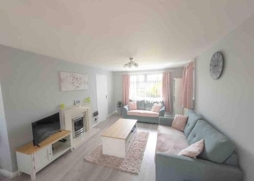 a living room with a couch and a fireplace at Crud Yr Awel, Dinas, Pembrokeshire in Dinas