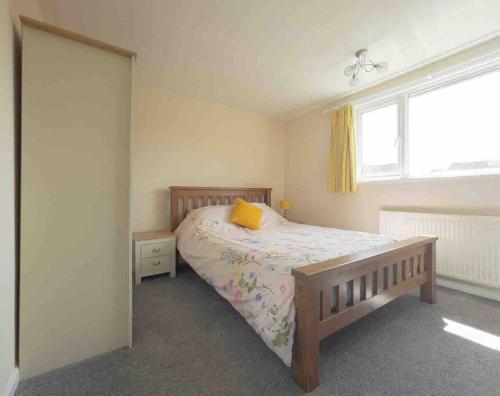 a bedroom with a bed with a yellow pillow on it at Crud Yr Awel, Dinas, Pembrokeshire in Dinas