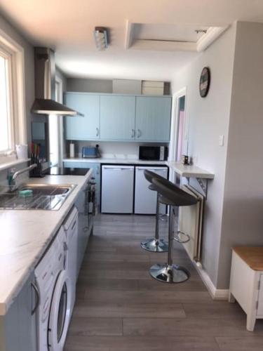 a kitchen with blue cabinets and a counter top at Crud Yr Awel, Dinas, Pembrokeshire in Dinas