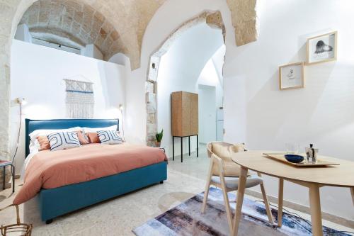 1 dormitorio con 1 cama y 1 mesa en Kalinifta - Jacuzzi & Suites SIT, en Lecce