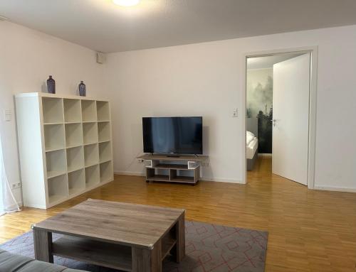 een woonkamer met een flatscreen-tv en een tafel bij Ferienwohungen Akwant in Baden-Baden