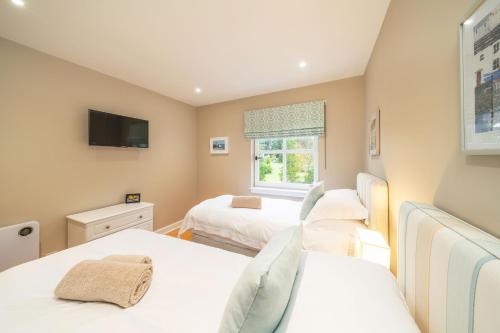 a bedroom with two beds and a tv at Strathallan - Luxury 3 Bedroom Apartment, Gleneagles, Auchterarder in Auchterarder