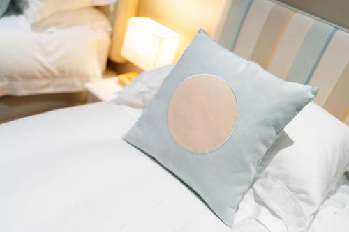 a pillow with a circle on it sitting on a bed at Strathallan - Luxury 3 Bedroom Apartment, Gleneagles, Auchterarder in Auchterarder