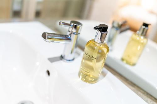a bottle of soap sitting on a bathroom sink at Strathallan - Luxury 3 Bedroom Apartment, Gleneagles, Auchterarder in Auchterarder