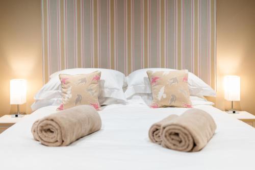 a white bed with two pillows and towels on it at Strathallan - Luxury 3 Bedroom Apartment, Gleneagles, Auchterarder in Auchterarder