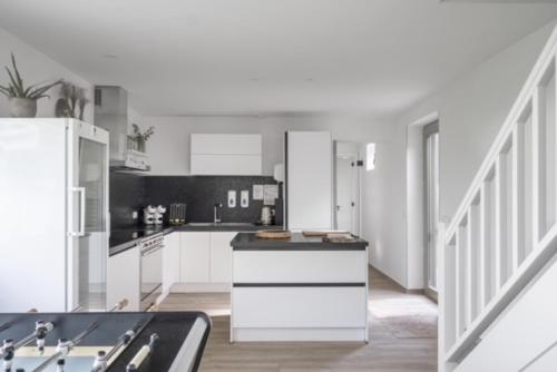 a kitchen with white cabinets and a black counter top at De Groene Bever in Lo-Reninge
