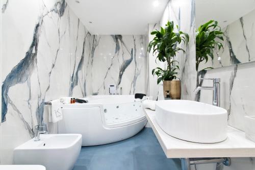 ein Badezimmer mit einem Waschbecken, einer Badewanne und einem WC in der Unterkunft Kalinifta - Jacuzzi & Suites SIT in Lecce