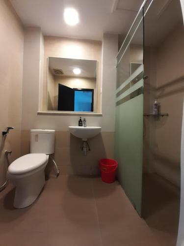 a bathroom with a toilet and a sink and a mirror at aparthotel cameron in Brinchang