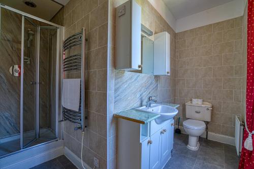 a bathroom with a sink and a shower and a toilet at Woodlands Bed and Breakfast in Dornoch