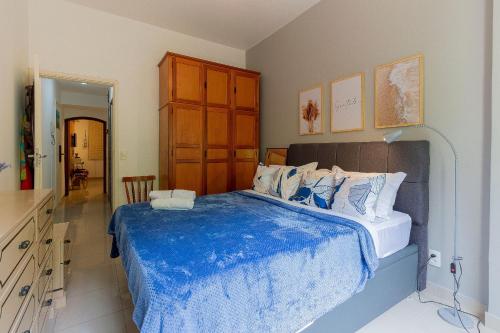 a bedroom with a large bed with a blue blanket at Copacabana Beachside Retreat in Rio de Janeiro
