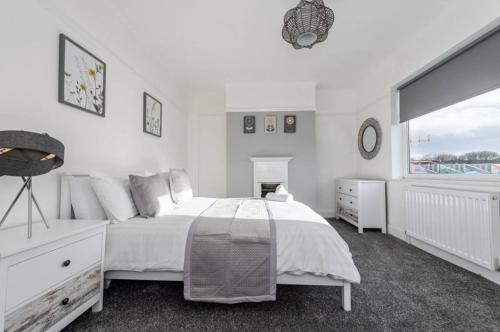 a white bedroom with a bed and a window at Liverpool TownHouse in Liverpool
