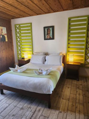 a bedroom with a large bed with two candles on it at Hotel Des Neiges in Cilaos
