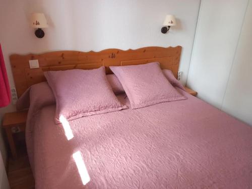 - une chambre avec un lit rose et 2 oreillers roses dans l'établissement T2 au pied des pistes, à Puy-Saint-Vincent