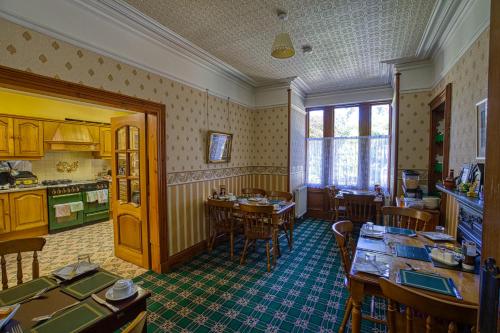 a kitchen and dining room with tables and chairs at Woodlands Bed and Breakfast in Dornoch