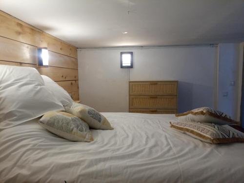 a white bed with two pillows on top of it at Studio d'aqui et d'ailleurs in Perpignan