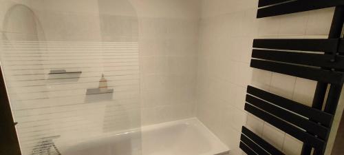 uma casa de banho branca com um chuveiro com uma porta de vidro em Apartmán 604 em Vrbno pod Pradedem