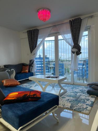 een woonkamer met een bank en een tafel bij The Coffee Residences- 3 Bedroom Apartments-4km to JKIA, 7km to CBD in Nairobi
