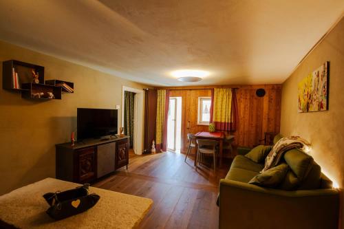 a living room with a couch and a television at La Noix - Alloggi ad uso turistico - VDA - ARVIER - n 0041 e n 0042 in Arvier