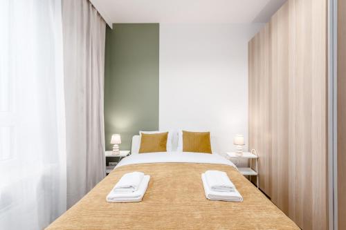 a bedroom with a large bed with two towels on it at Warsaw City Jutrzenki Premium in Warsaw