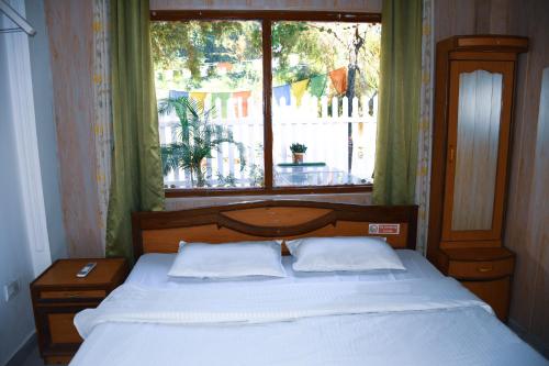 a bed in a bedroom with a large window at River Stay - Homestay by Wanderlust Rural Tourism in Dehradun