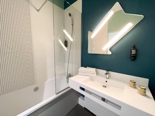 a bathroom with a white sink and a shower at Ibis Budget Saint Christol Les Alès in Saint-Christol-lès-Alès