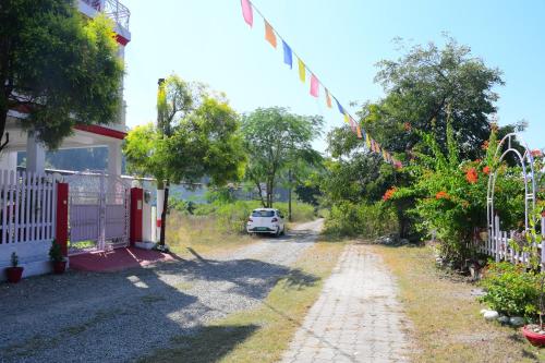 a house with a car parked next to a driveway at River Stay - Homestay by Wanderlust Rural Tourism in Dehradun