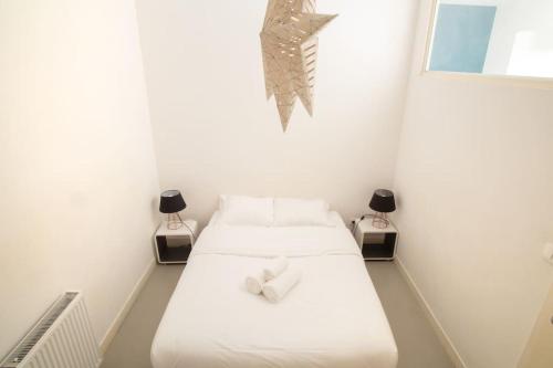 um quarto branco com 2 camas e 2 candeeiros em Saint-Thomas 2 - Joli T2 dans Strasbourg em Estrasburgo