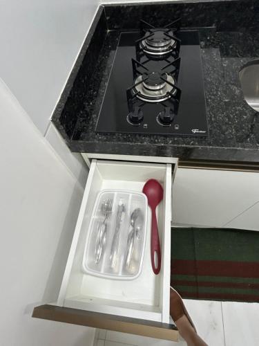 a spatula and utensils in a drawer next to a stove at Melhores Flats - Tranquilo, pertinho do mar in João Pessoa