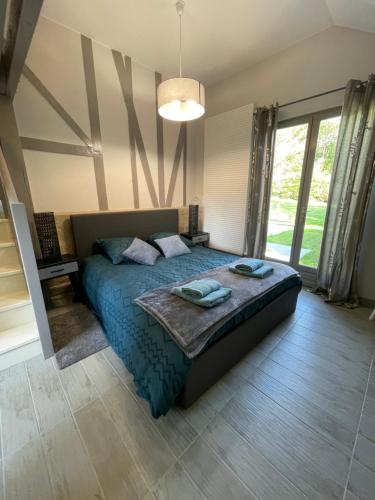 une chambre avec un lit dans une pièce avec des fenêtres dans l'établissement Maison, cottage, à Choisy-au-Bac