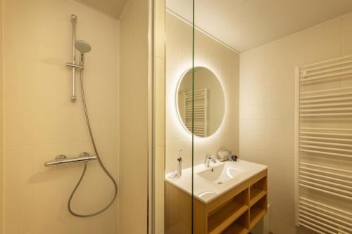 a bathroom with a shower and a sink and a mirror at Center Parcs Limburgse Peel Limburg-Brabant in America