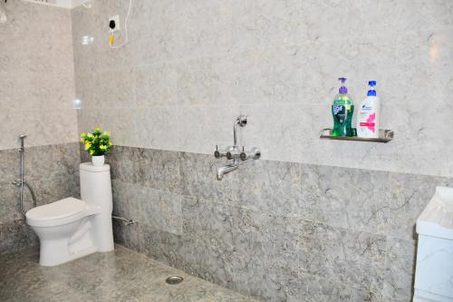 a bathroom with a toilet and two bottles on a wall at River Stay - Homestay by Wanderlust Rural Tourism in Dehradun