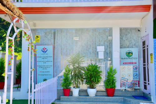 a store front with potted plants in front of it at River Stay - Homestay by Wanderlust Rural Tourism in Dehradun