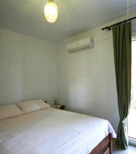 a bedroom with a white bed and a window at Ktima Apostolou in Aspropótamos