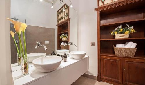 łazienka z 2 umywalkami na blacie z kwiatami w obiekcie Princess house Roma w Rzymie