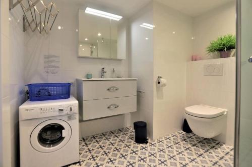 a bathroom with a washing machine and a toilet at Mésange - Studio au centre de Strasbourg in Strasbourg