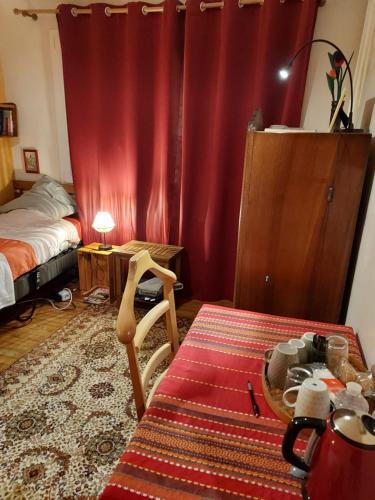 - une chambre avec un lit et un rideau rouge dans l'établissement Bn'B Juno Beach 5' de la plage !, à Bernières-sur-Mer