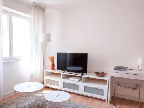 sala de estar blanca con TV y 2 mesas en Le Phalsbourg - Escapade citadine à Strasbourg en Estrasburgo