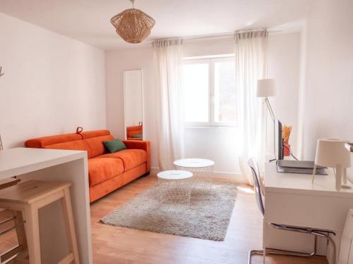 sala de estar con sofá naranja y mesa en Le Phalsbourg - Escapade citadine à Strasbourg en Estrasburgo