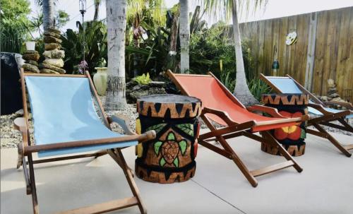 Merritt Island的住宿－Tropical Retreat Near Beaches, Cruise Terminals，一组椅子坐在庭院里