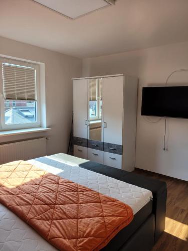 a bedroom with a bed and a flat screen tv at Schöne einfache Ferienwohnung zwischen Stadt und Meer in Wilhelmshaven