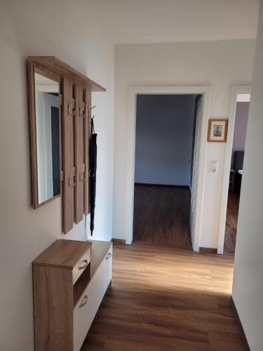 a room with a dresser and a mirror and a hallway at Schöne einfache Ferienwohnung zwischen Stadt und Meer in Wilhelmshaven