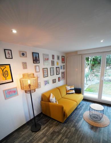 un salon avec un canapé jaune et une lampe dans l'établissement The Green Garden Spa & Serenity, à Mittelhausbergen