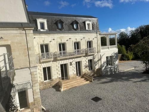 ロシュコルボンにあるLe Petit Versailles Loire Toursのバルコニー付きの大きなレンガ造りの建物です。