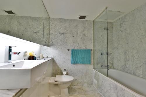 a bathroom with a sink and a toilet and a shower at CBD Harbour Retreat - Lovely 2BR Home in Sydney